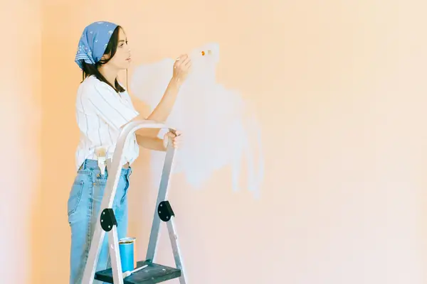Interior painting in Spokane: painter on a stepladder rolling a wall